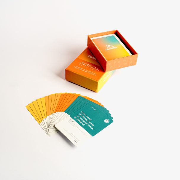 Colourful card deck displayed with its box, featuring gradient orange and teal designs.