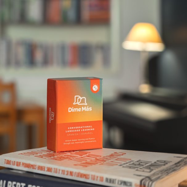 Box of DineMix on top of books, with blurred bookshelf and lamp in background.
